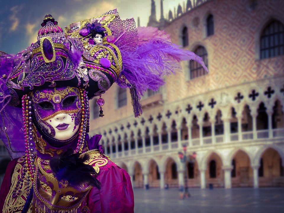 Persona vestita per il carnevale di venezia che indossa abiti d'oro
